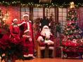 Santa, Mrs. Claus, and children on stage inside Kramer Center at the Christmas Party