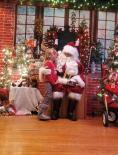 Santa pm stage with a child at Kramer Homes Christmas Party