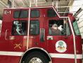 Santa, Ms. Claus, and children in fire truck at Kramer Homes Christmas Party